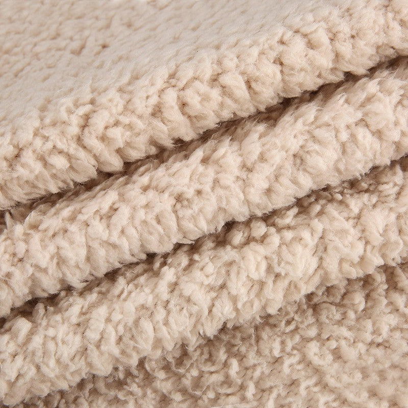 Närbild på beige plyschtyg i husdjursmattan