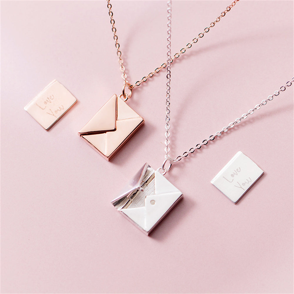 Kuverthängsmycken i silver, guld och roséguld på rosa bakgrund