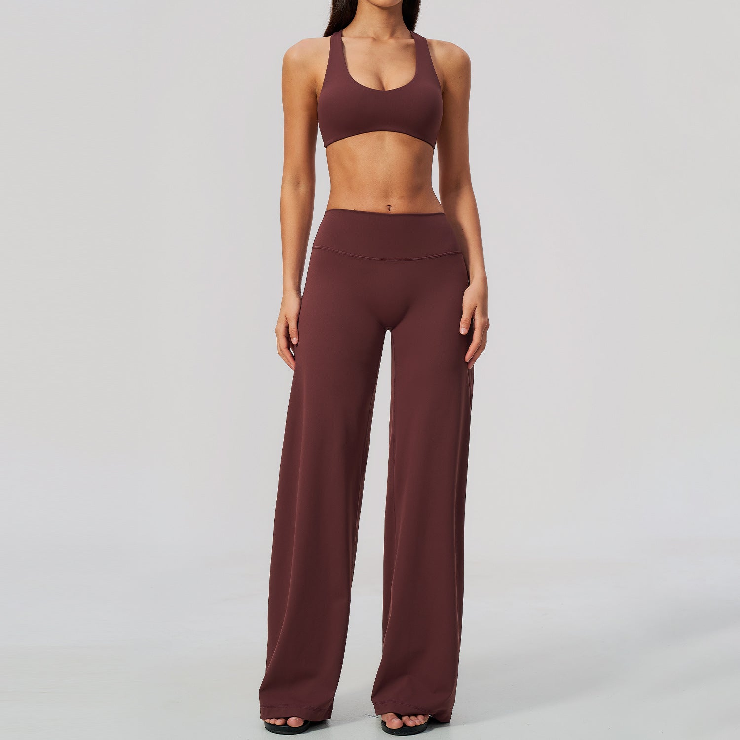 Vinrött yogaset med korsad topp och högmidjade vida byxor på modell