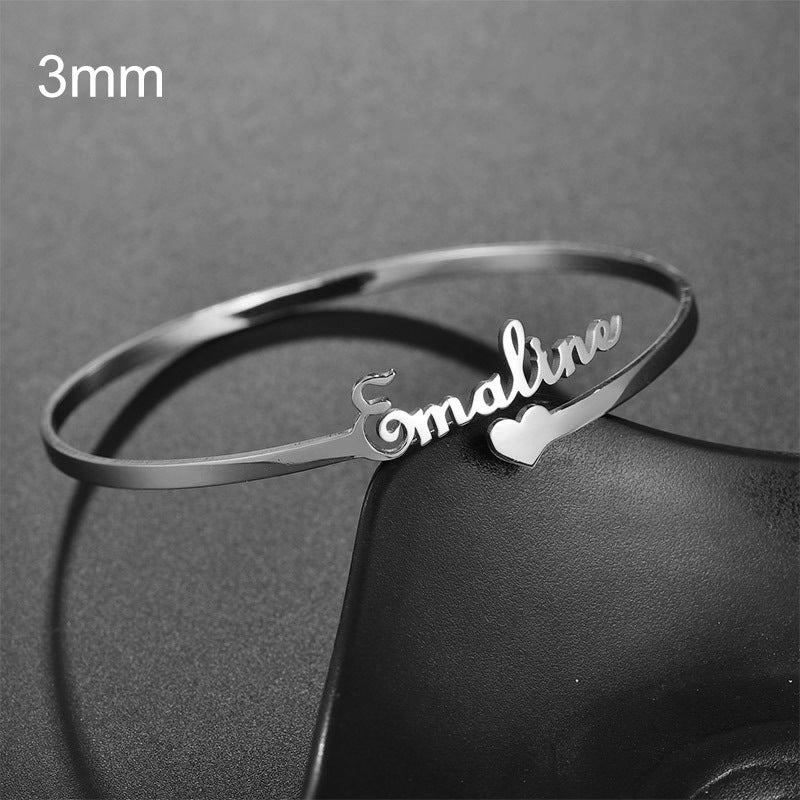 Silverfärgad tunn bangle med namn och litet hjärta