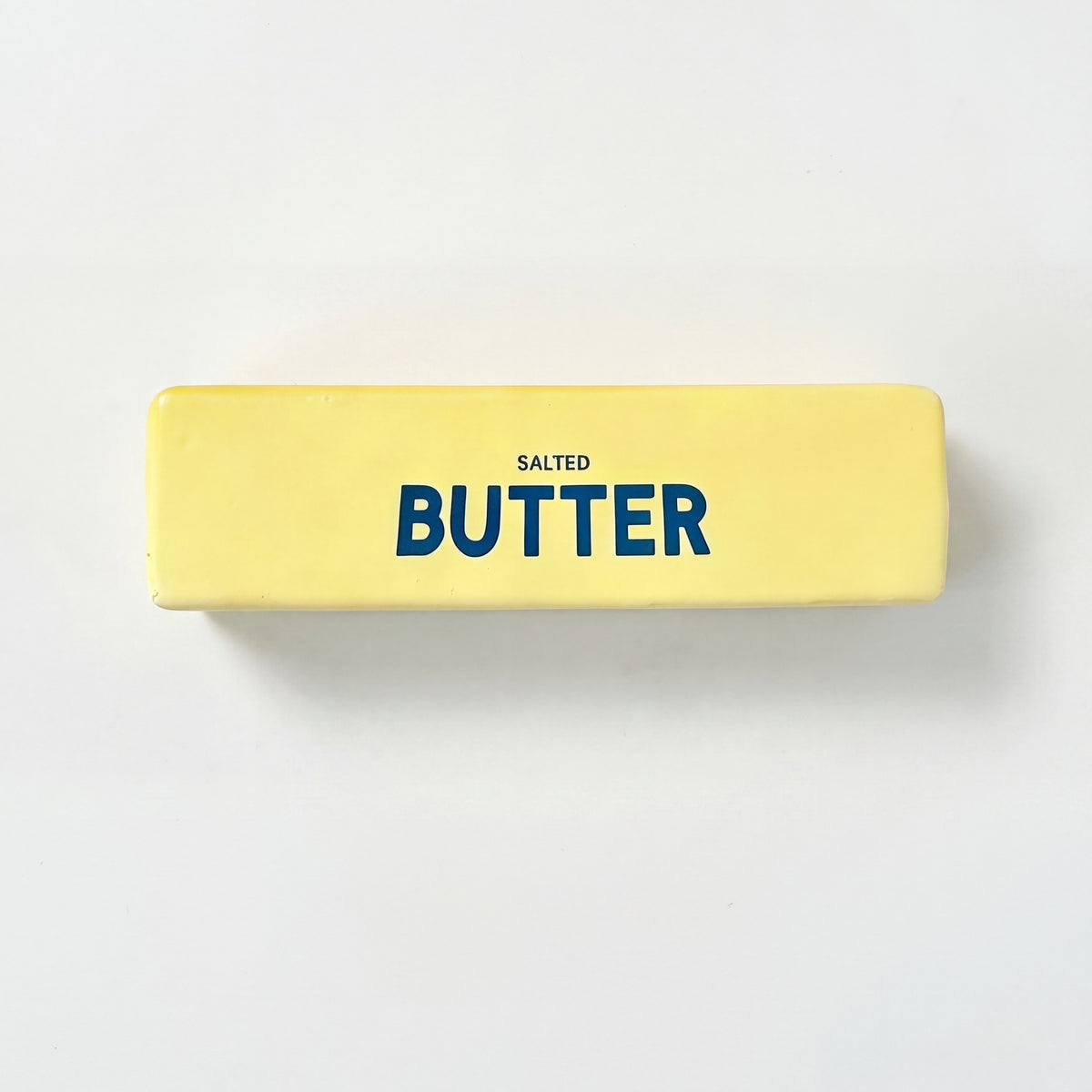 Stressleksak smorpaket salted butter pa neutral bakgrund