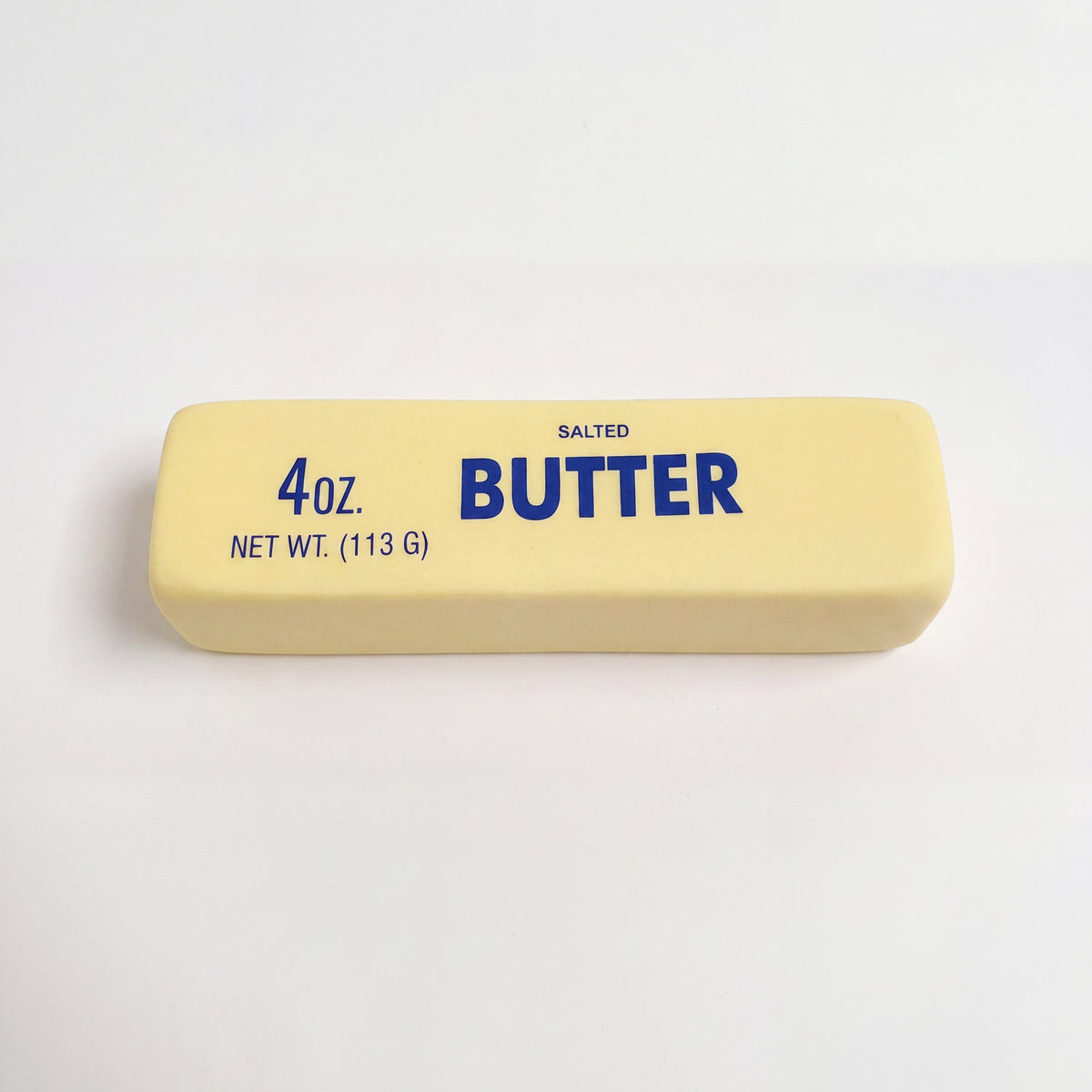 Stressleksak smorpaket 4 oz salted butter utan plastfilm pa neutral bakgrund
