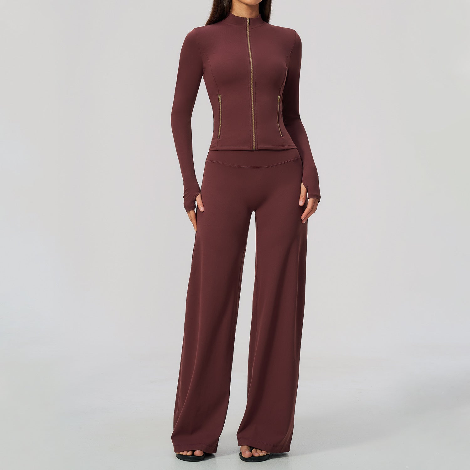 Vinrött yogaset med långärmad zipjacka och vida bootcut-byxor på modell