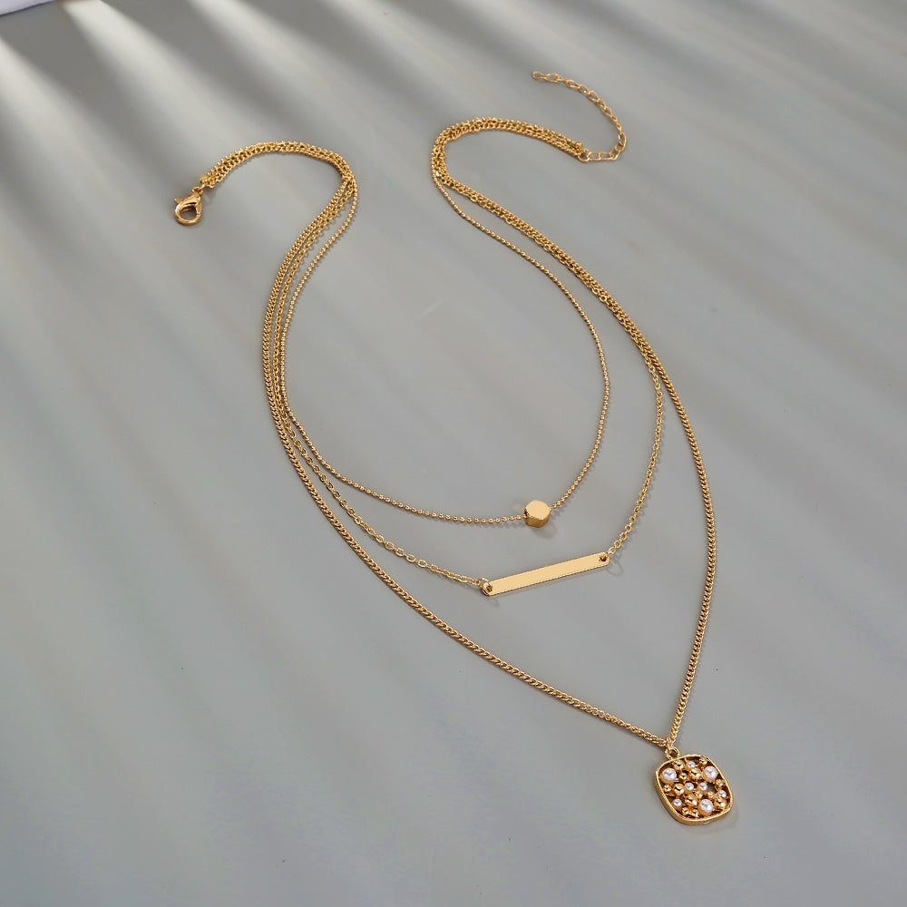 Halsband i flera lager med geometriskt ananashänge