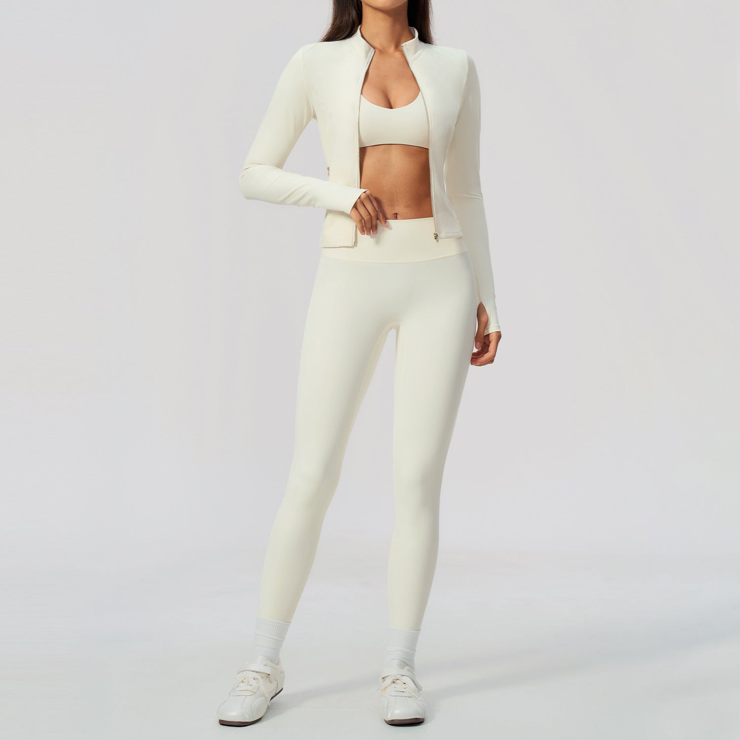 Krämvitt yogaset med bh-topp, högmidjade tights och kort jacka med dragkedja